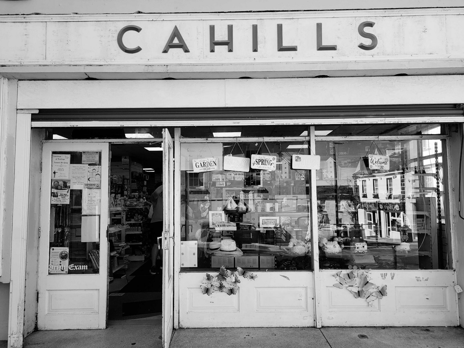 The storefront of Cahills with a glass window displaying various items and signs.