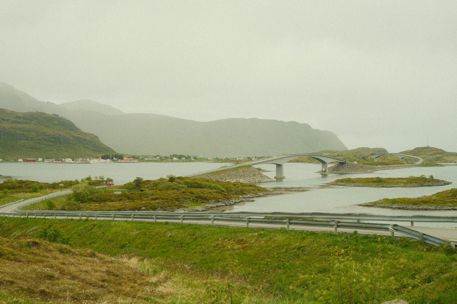 Road and bridge connecting misty islands and distant mountains.
